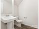 Powder room features wood-look floors, pedestal sink, and neutral paint at 3312 James Rd, Charlotte, NC 28215