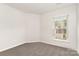 Cozy bedroom featuring neutral walls, plush carpeting, and a window at 3312 James Rd, Charlotte, NC 28215