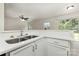 Bright kitchen with white cabinets and countertops, complemented by modern stainless steel sink fixture at 3312 James Rd, Charlotte, NC 28215
