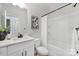 Modern bathroom with a white vanity, black hardware, and a combined tub and shower with white tile surround at 3314 & 3316 Cedarhurst Dr, Charlotte, NC 28269