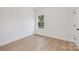 Empty bedroom with neutral walls, light wood floors, and a window providing natural light at 3314 & 3316 Cedarhurst Dr, Charlotte, NC 28269