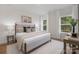 A serene bedroom with neutral tones, a plush rug, and ample natural light from two large windows at 3314 & 3316 Cedarhurst Dr, Charlotte, NC 28269