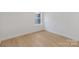 Empty bedroom with neutral walls, light wood floors, and a window providing ample natural light at 3314 & 3316 Cedarhurst Dr, Charlotte, NC 28269