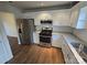 Modern kitchen featuring stainless steel appliances, granite countertops, subway tile backsplash, and hardwood flooring at 3912 Laurel View Cir, Indian Trail, NC 28079