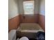 A bathroom showing a bathtub with peach tiles and natural light at 407 Lincoln St, Wadesboro, NC 28170