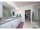 Spacious bathroom featuring double sinks, granite counters, and doorway to walk-in closet at 4245 Millstream Rd, Denver, NC 28037