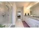Bright bathroom showcasing a glass enclosed shower, dual sinks and walk-in closet access at 4245 Millstream Rd, Denver, NC 28037