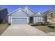 Charming light blue home featuring a two-car garage, well-manicured lawn, and nicely landscaped front yard at 4245 Millstream Rd, Denver, NC 28037
