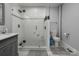 Modern bathroom featuring a glass-enclosed shower with white subway tile and stone floor, along with a gray vanity and toilet at 443 Brandon St, Davidson, NC 28036