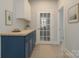 Bright mudroom boasts blue cabinetry, butcher block counters, and a charming French door to the exterior at 443 Brandon St, Davidson, NC 28036