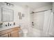 Bright bathroom features marble floors, wooden vanity, framed mirror, and shower-tub combination at 4547 Kings Ct, Hickory, NC 28602