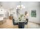 Open-concept dining area boasts a modern chandelier, wood floors, and a view of the staircase at 4547 Kings Ct, Hickory, NC 28602