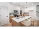 Modern kitchen features white cabinets, stainless steel appliances, a gray backsplash, and an island at 4547 Kings Ct, Hickory, NC 28602