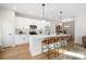 Modern kitchen boasts white cabinetry, stainless steel appliances, and an eat-in island with stylish bar stools at 4815 & 4817 Victoria Dr, Charlotte, NC 28269