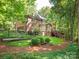 Exterior view of the home showcasing brick exterior, backyard, and expansive deck at 5417 Bedfordshire Ave, Harrisburg, NC 28075