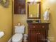Charming half bathroom featuring dark wood vanity and gold hardware at 5417 Bedfordshire Ave, Harrisburg, NC 28075