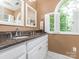 Spacious bathroom with double vanity sinks, granite countertops, and bright lighting from the window at 5417 Bedfordshire Ave, Harrisburg, NC 28075