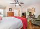 Well-lit bedroom with hardwood floors, ceiling fan, connected office, and a comfortable armchair at 5417 Bedfordshire Ave, Harrisburg, NC 28075