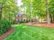 Beautiful brick home with well-manicured lawn and mature trees, providing a welcoming curb appeal at 5417 Bedfordshire Ave, Harrisburg, NC 28075