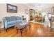 Cozy living room with hardwood floors, adjacent to dining area, with a china cabinet, and a blue sofa at 5417 Bedfordshire Ave, Harrisburg, NC 28075