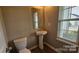 Well-lit bathroom with a pedestal sink and classic fixtures at 5823 Natick Dr, Charlotte, NC 28214
