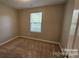 Neutral bedroom featuring wall to wall carpeting and a bright window for natural light at 5823 Natick Dr, Charlotte, NC 28214