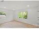 Bright bedroom with hardwood floors and natural light from dual windows overlooking lush greenery at 5910 Grosner Pl, Charlotte, NC 28211