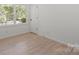 Bright bedroom features hardwood floors, a large window, and neutral walls at 5910 Grosner Pl, Charlotte, NC 28211