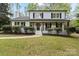 Charming two-story home with a covered front porch, landscaped yard, and fresh white and black paint at 5910 Grosner Pl, Charlotte, NC 28211