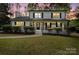 Charming two-story home with a covered front porch, landscaped yard, and fresh white and black paint at 5910 Grosner Pl, Charlotte, NC 28211