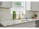 Close-up of kitchen showcasing marble countertops, modern faucet, and white cabinets at 5910 Grosner Pl, Charlotte, NC 28211