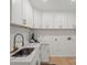 Bright laundry room features stylish white cabinets with gold hardware and marbled countertops at 5910 Grosner Pl, Charlotte, NC 28211