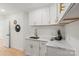 Bright laundry room features stylish white cabinets with gold hardware and marbled countertops at 5910 Grosner Pl, Charlotte, NC 28211