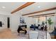 Open living room featuring hardwood floors, wooden beams, a modern fireplace, and stylish decor at 5910 Grosner Pl, Charlotte, NC 28211
