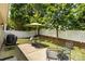 This backyard features a white fence, a patio with outdoor furniture and grill, and lovely trees at 611 Tee Ridge Ct, Fort Mill, SC 29715