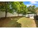 The backyard features a patio, a full green lawn, a white fence, and multiple mature trees at 611 Tee Ridge Ct, Fort Mill, SC 29715