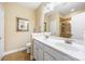 Bright bathroom with double sinks, white cabinets, and a decorative framed mirror at 611 Tee Ridge Ct, Fort Mill, SC 29715