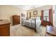 Well-lit bedroom with an iron bed frame, neutral carpet, and a classic dresser at 611 Tee Ridge Ct, Fort Mill, SC 29715