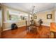 Dining room with hardwood floors, glass table, chandelier, and open to the living area at 611 Tee Ridge Ct, Fort Mill, SC 29715
