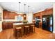 Spacious kitchen featuring dark wood cabinets, granite countertops, and a central island with seating at 611 Tee Ridge Ct, Fort Mill, SC 29715