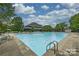 Community pool with a diving board and deck chairs are surrounded by beautiful mature trees at 611 Tee Ridge Ct, Fort Mill, SC 29715