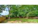 Spacious backyard with a wood fence, lush greenery, and a bench under the shade of a mature tree at 625 N Center St # 4, Statesville, NC 28677