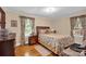 Comfortable bedroom with hardwood floors, floral patterned bedding, and windows letting in natural light at 625 N Center St # 4, Statesville, NC 28677