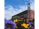 Clock tower on building with bright flowers in the foreground, under a blue sky with clouds at 625 N Center St # 4, Statesville, NC 28677