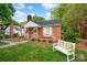 Charming red brick home with a chimney, shutters, manicured landscaping and a garden bench at 625 N Center St # 4, Statesville, NC 28677