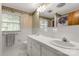 Well-lit bathroom showcasing a dual sink vanity, floral wallpaper and plenty of natural light at 709 Plantation Rd, Lancaster, SC 29720