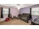 Cozy bedroom with a gray crib, chair, and soft carpet, illuminated by natural light from a window at 709 Plantation Rd, Lancaster, SC 29720