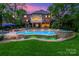 Stunning backyard with a large swimming pool, hot tub, stone accents, and a spacious patio area at 7812 Seton House Ln, Charlotte, NC 28277