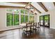 Sunlit dining room with wood beam ceilings, large windows, and access to an outdoor grill at 7812 Seton House Ln, Charlotte, NC 28277