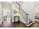 Bright foyer with hardwood floors, white staircase with black accents, and elegant decor at 7812 Seton House Ln, Charlotte, NC 28277